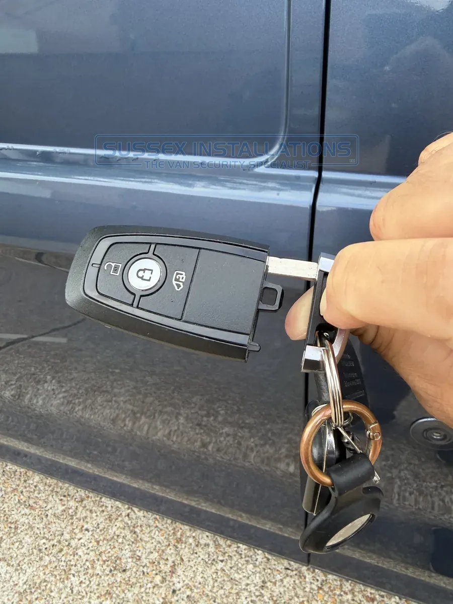 Pressing the two-line button to separate the key blade from the Ford Custom remote control