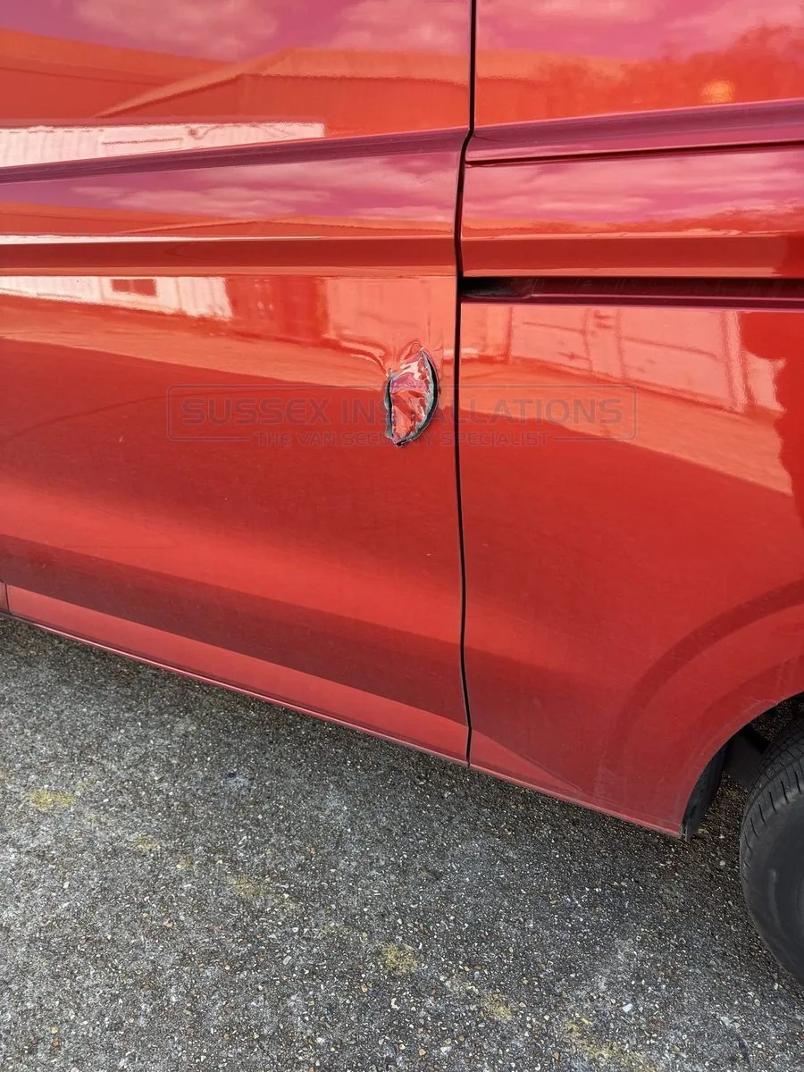 A hole made through a Ford Custom door in a break-in attack