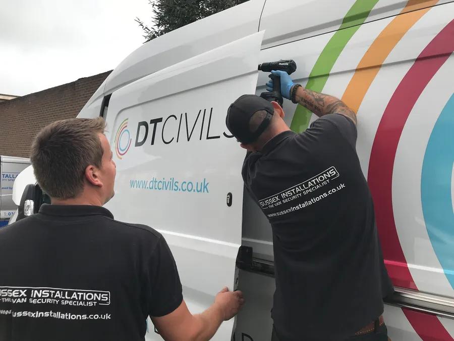 Sussex Installations technicians fitting locks to a DT Civils fleet van