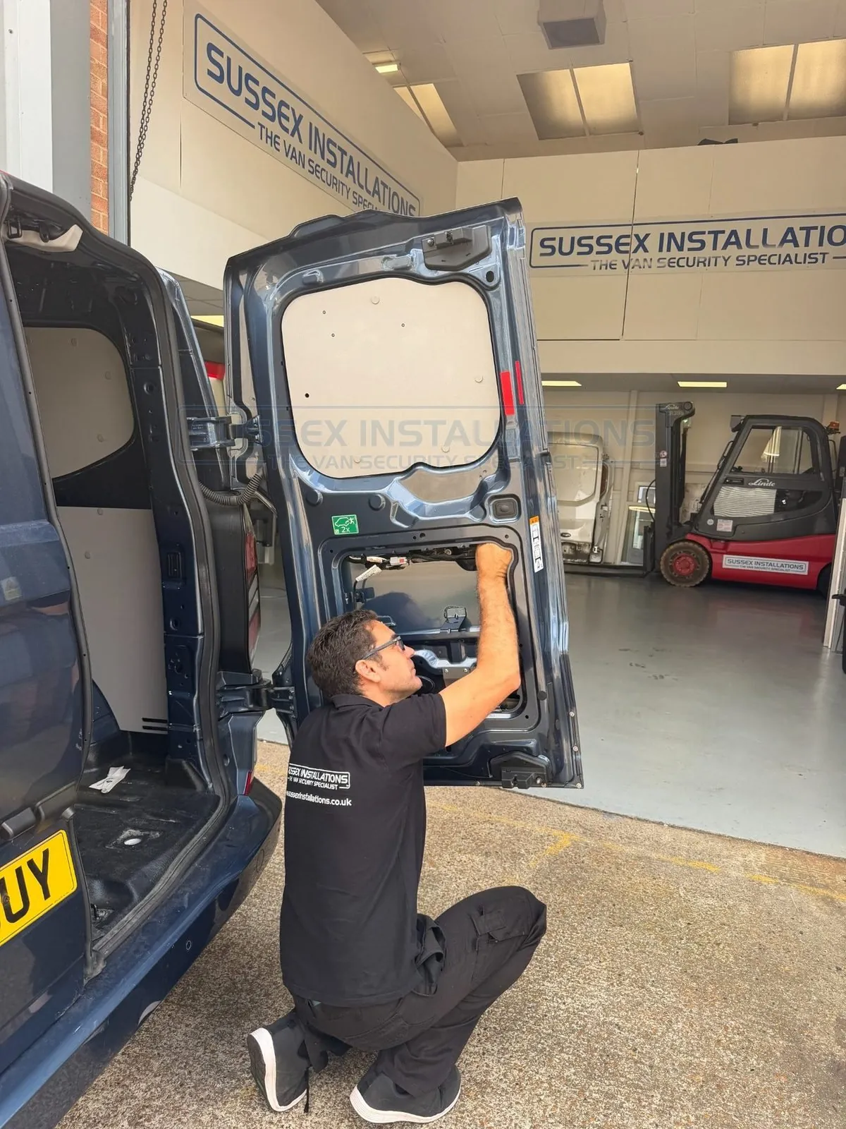 Jeff Scott inspecting wiring and internal components inside a van door