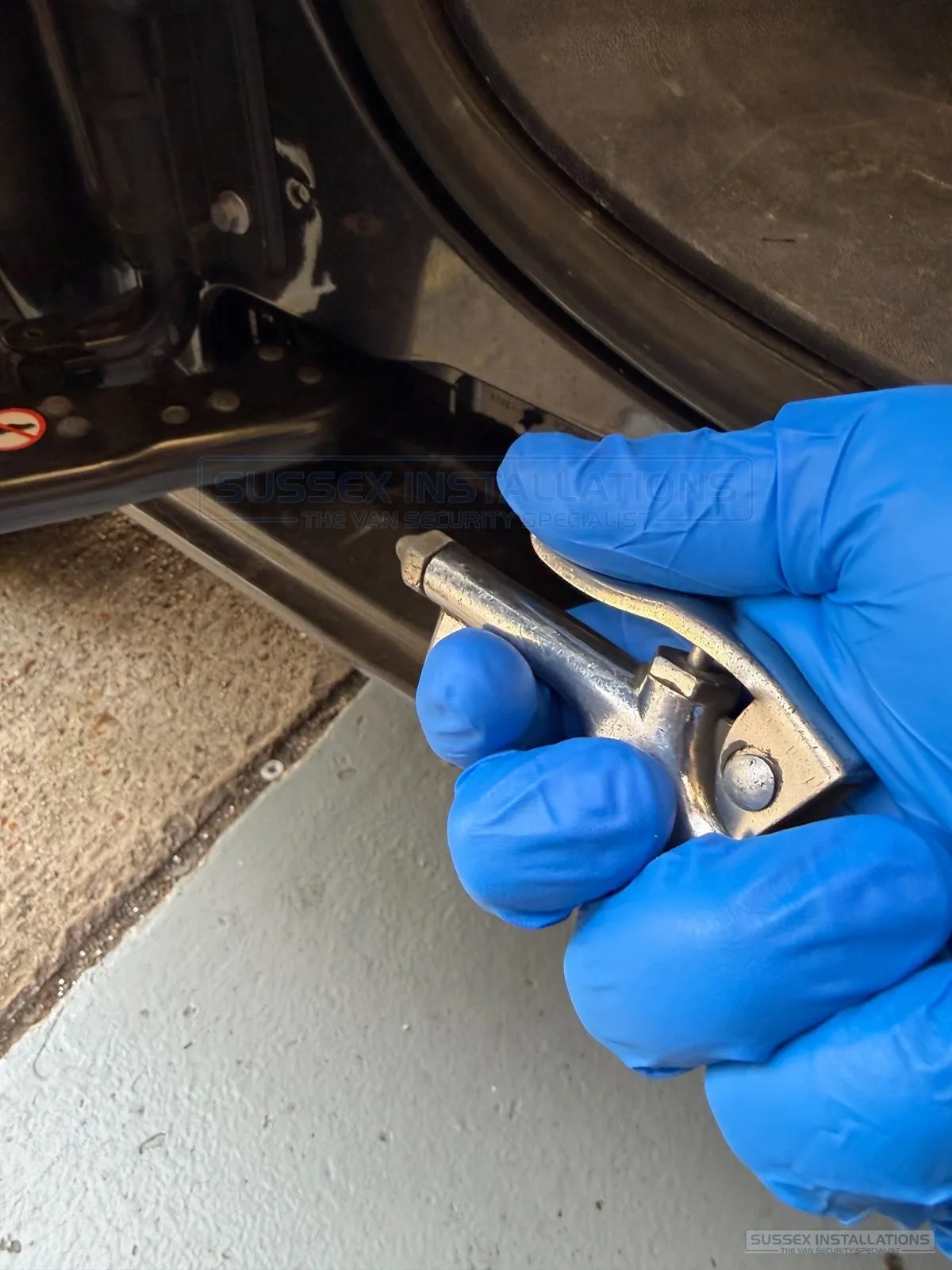 Compressed-air blow gun cleaning debris from a van door opening