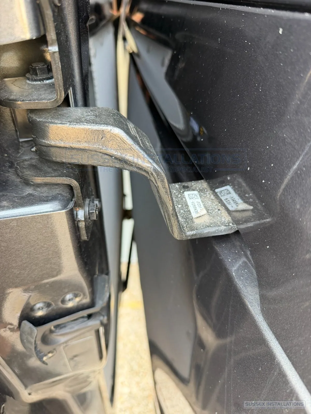 Metal swarf resting on a van hinge and painted bodywork