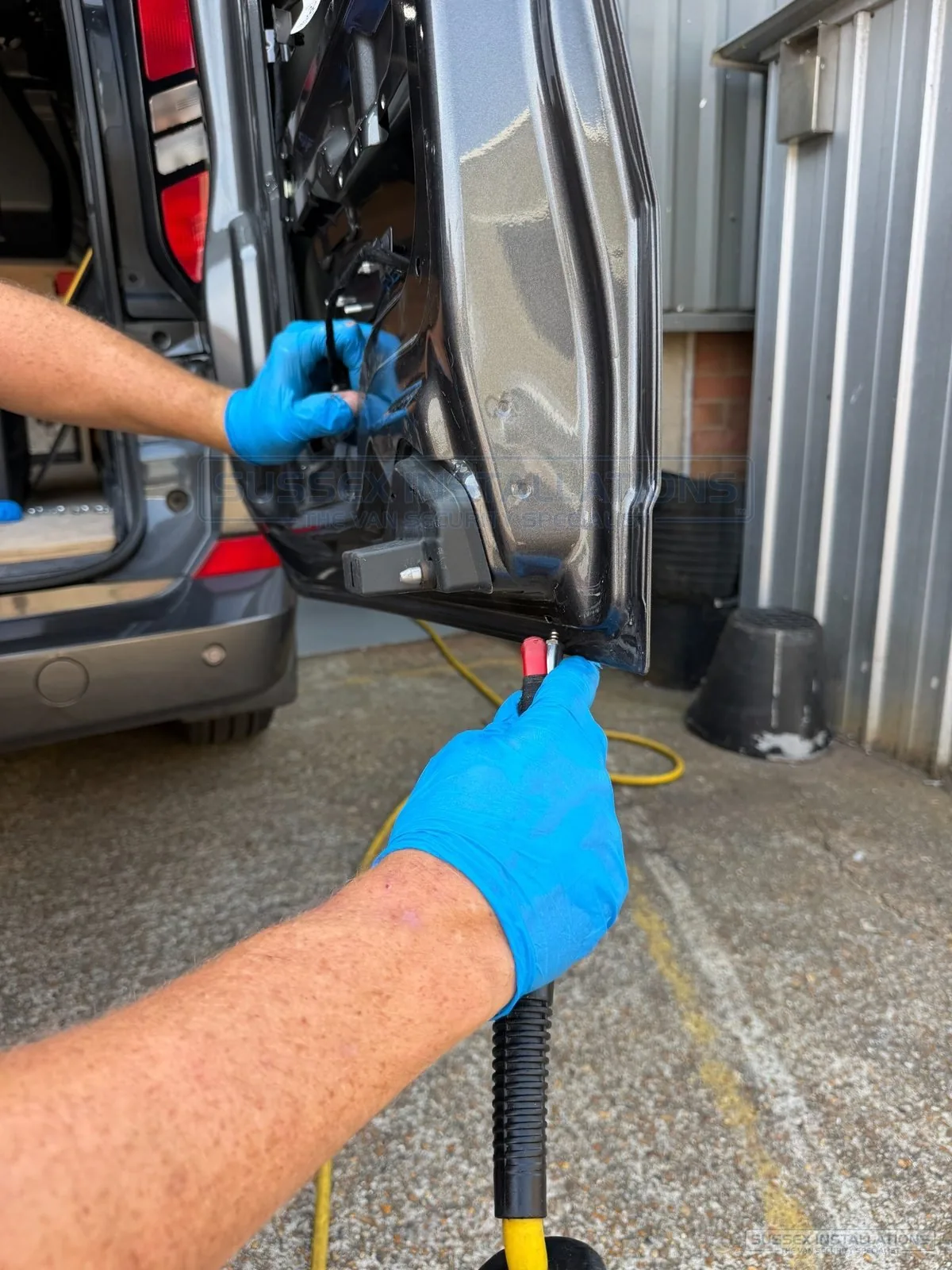 Compressed air cleaning the lower inside of a rear van door