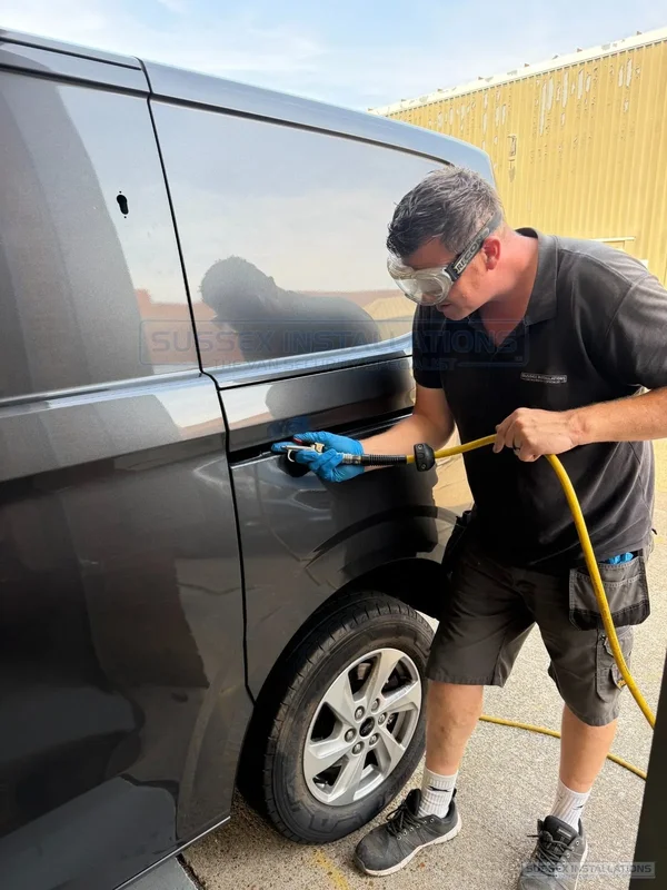 Installer using compressed air around a van exterior handle