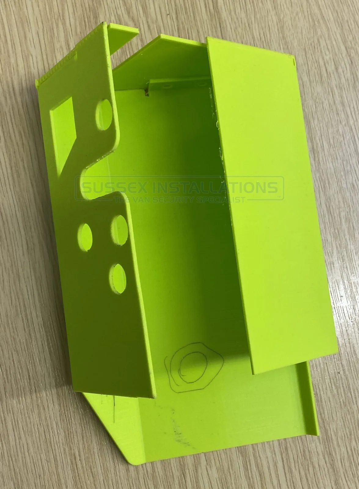 An early 3D-printed prototype van security shield in green plastic, marked up by hand for further modification