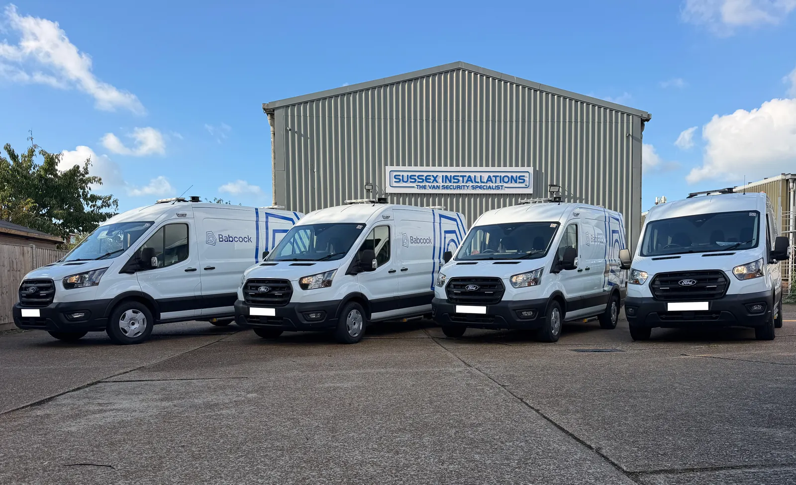 Four fleet service vans lined up outside the Sussex Installations workshop in Eastbourne after security fitting