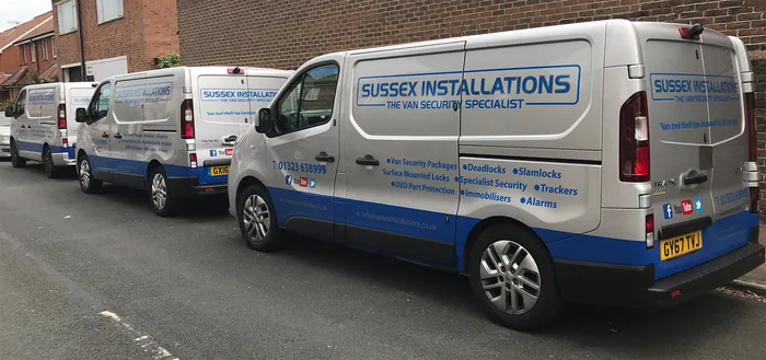 Fleet of branded Sussex Installations mobile installation vans parked in a row