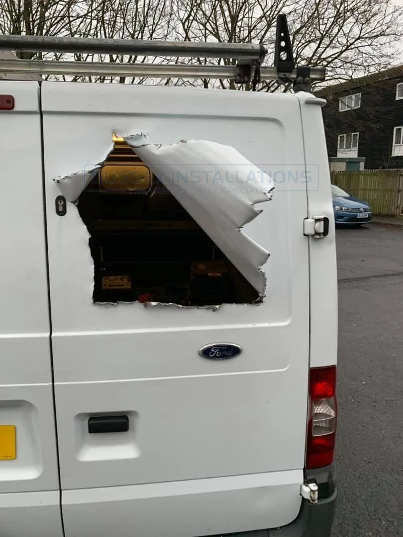 A hole cut through the rear panel of a Ford Transit